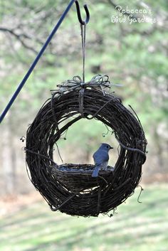 a bird is sitting in a nest hanging from a wire