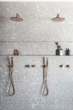 three shower heads mounted to the side of a wall