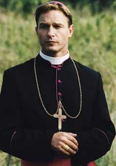 a man in a priest's outfit with a cross on his chest and chain around his neck