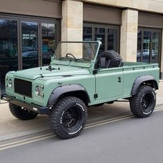 a green truck parked on the side of a street