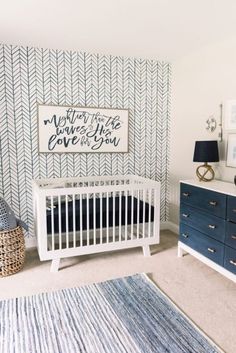 a baby's room with blue dressers and white crib in the corner