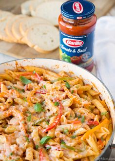 a pan filled with pasta and sauce next to sliced bread