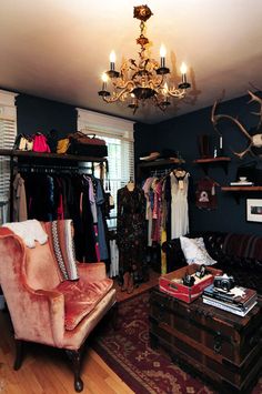 a living room filled with lots of furniture and a chandelier hanging from the ceiling