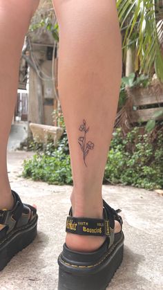 a woman's foot with a small flower tattoo on her left leg and the words, i love you