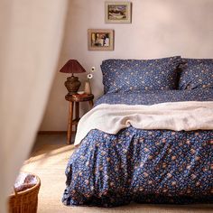 a bed with blue and white bedspread in a bedroom next to a lamp