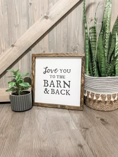 a sign that says love you to the barn and back next to potted plants