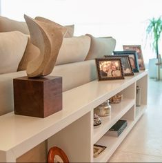 a living room filled with lots of furniture and pictures on top of the shelfs