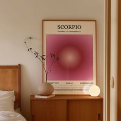 a poster hangs on the wall next to a bed with pillows and a vase filled with flowers