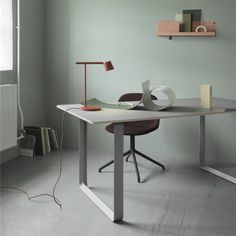 an empty room with a desk, chair and lamp on the floor in front of a radiator