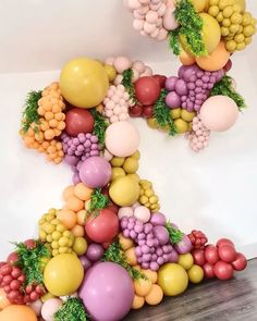 a number made out of balloons and grapes