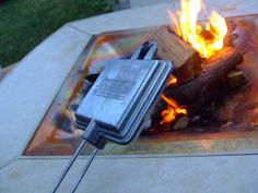 an open fire pit with some kind of electronic device on it's burner