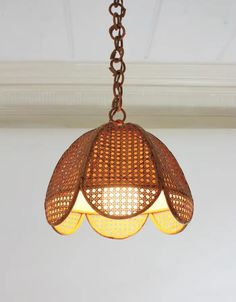 a light fixture hanging from a ceiling in a room with white walls and wood trimmings