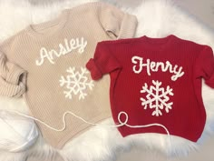 two knitted sweaters with snowflakes on them, one is red and the other is beige