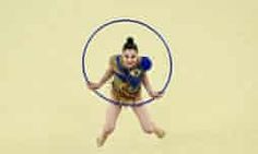 a woman is in the air with a hula hoop around her waist and feet