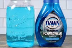 a bottle of dawn dish soap next to a jar of powerwash detergent on a table