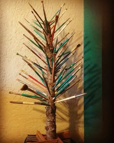 a small tree with many different colored sticks sticking out of it