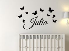 a white crib with butterflies and the name julia on it