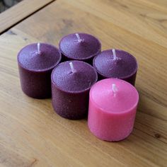 four candles sitting on top of a wooden table