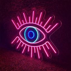 a neon sign with an eye in the center and some lights on top of it