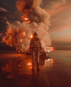 a man standing in front of a burning car