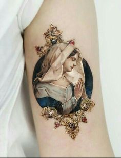 a woman's arm with a tattoo on it that has an image of the virgin mary