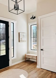 a white room with black doors and two windows