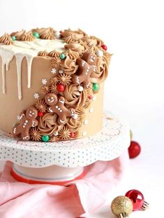 a chocolate cake with frosting and christmas decorations on top, sitting on a table