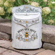 a white beehive mailbox sitting on top of a brick wall