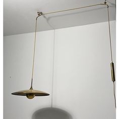 a lamp hanging from the ceiling in a room with white walls and flooring,