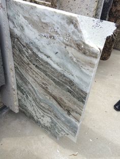 a marble slab with writing on it sitting next to a pair of black shoes in a room