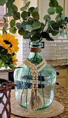 a vase filled with flowers on top of a table next to a potted plant