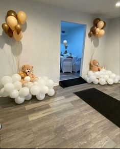 balloons and teddy bears are on display in the entryway to a party with white table cloths