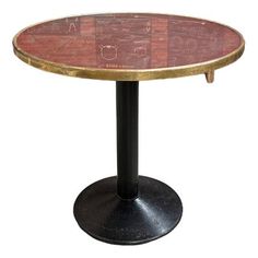 a round glass table with black base and gold trimmings on the top, against a white background