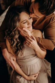 a pregnant woman is hugging her husband's belly