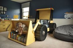 a child's bedroom with blue walls and yellow construction truck bed in the corner