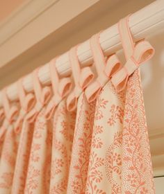 an orange and white curtain hanging from a window