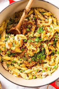 a large pot filled with pasta and meat covered in parmesan cheese, herbs and seasoning