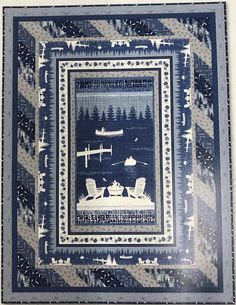 a blue and white quilt with an airplane in the sky on it's border