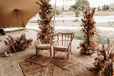 an outdoor area with chairs and flowers on the ground, near a large open umbrella