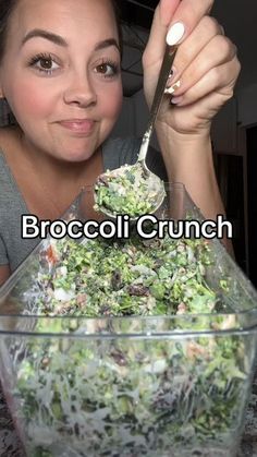 a woman holding a spoon over a bowl filled with salad