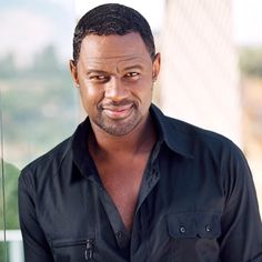 a man in black shirt looking at the camera