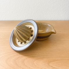 two small ceramic bowls sitting on top of a wooden table next to each other,