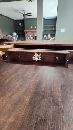 a close up of a wooden table with drawers on the bottom and one drawer open