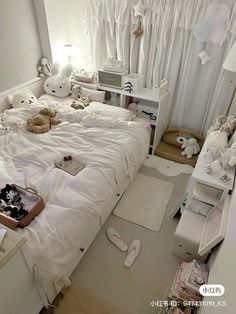 there is a bed with white sheets and teddy bears on the pillows in this room