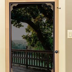 an open door with the reflection of a tree in it and a wooden deck below