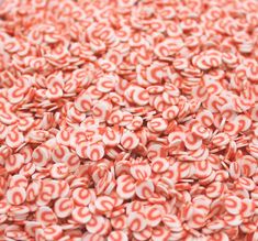 a large pile of candy canes sitting on top of each other in red and white