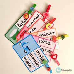 several colorful name tags on a white surface with clippings attached to each one