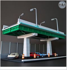 two cars are parked under a green and white bridge