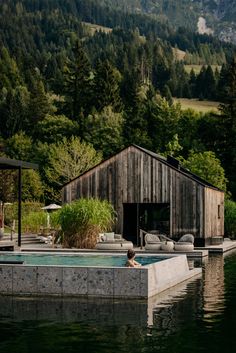 an outdoor hot tub in the middle of a body of water with mountains in the background