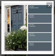 a blue front door with white flowers and greenery in the foreground below it